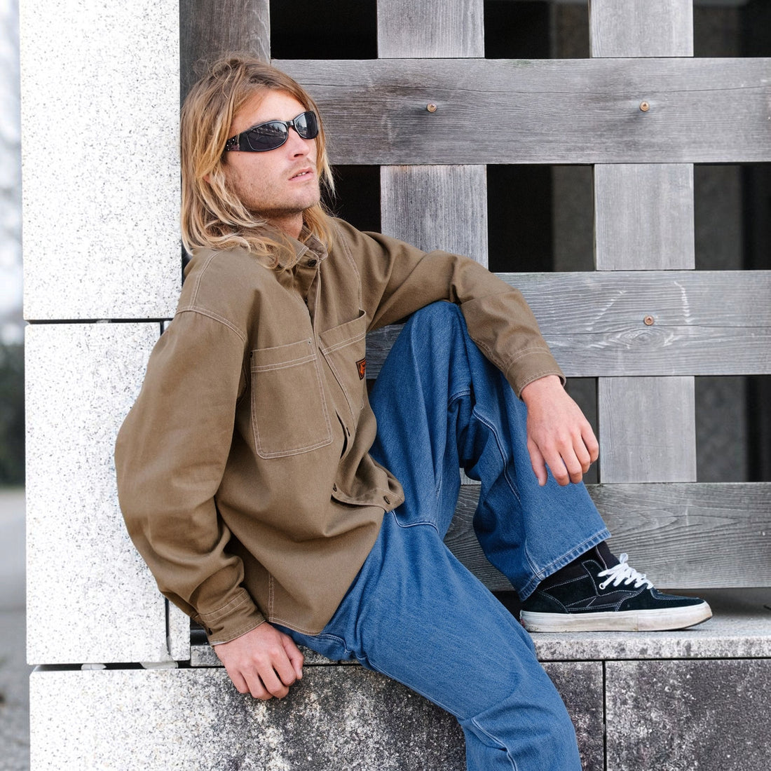 Homme portant une chemise Born2ride Volcom Levelstone LS couleur terre en coton avec un jean bleu et des lunettes