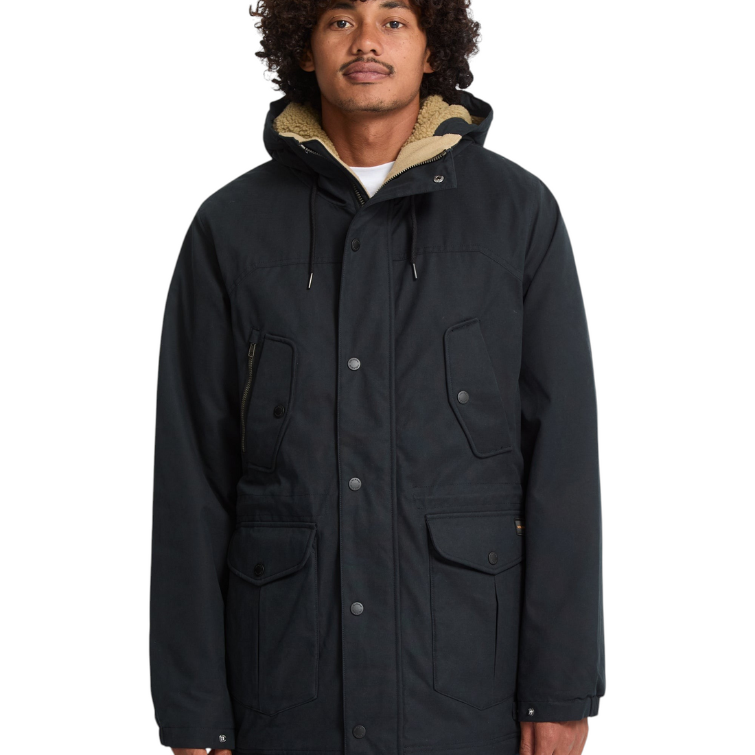 Homme portant la parka noire Volcom Starget 5K avec capuche doublée en sherpa, style streetwear technique