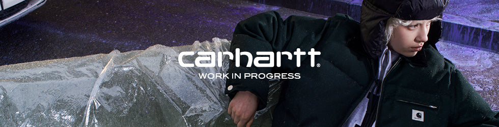Carhartt WIP - jeune en doudoune verte assis sur un canape recouvert de glace