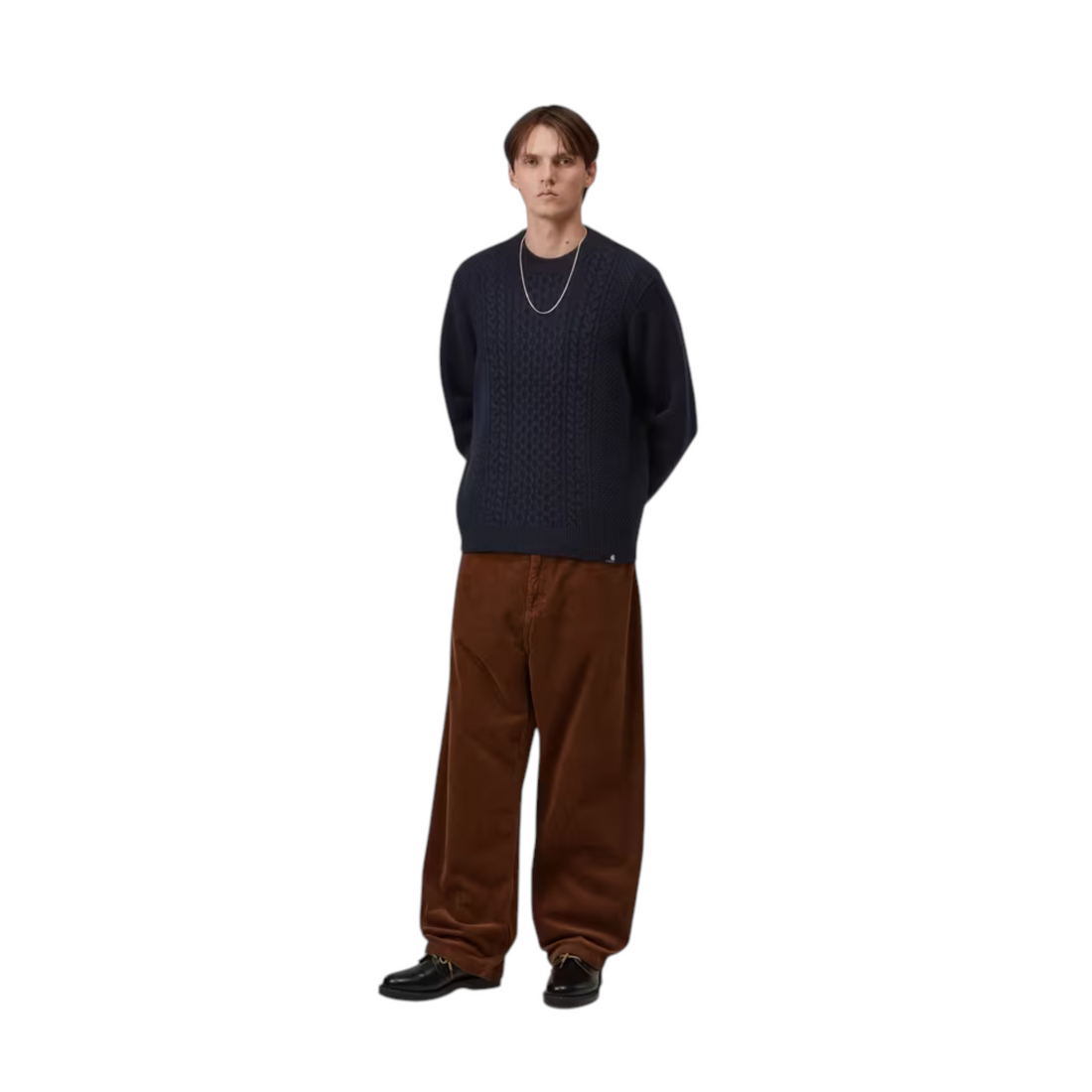 Homme portant un pull Born2ride Carhartt WIP Caster en maille torsadée bleu marine avec un pantalon en velours marron