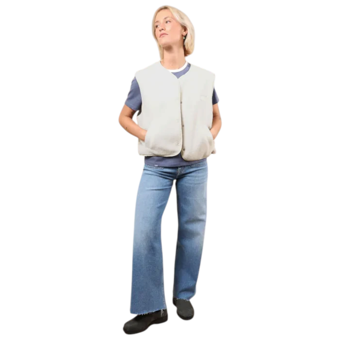 Femme portant le gilet réversible Born2ride Oxbow Twin en sherpa couleur snow sur un t-shirt bleu et un jean