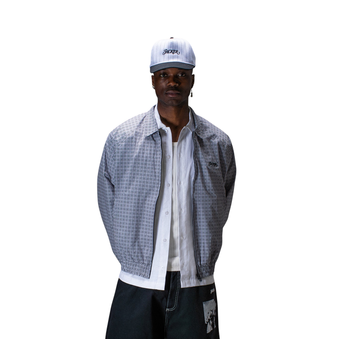 Homme portant une veste Born2ride Jacker à carreaux gris et blancs avec une casquette assortie sur fond gris