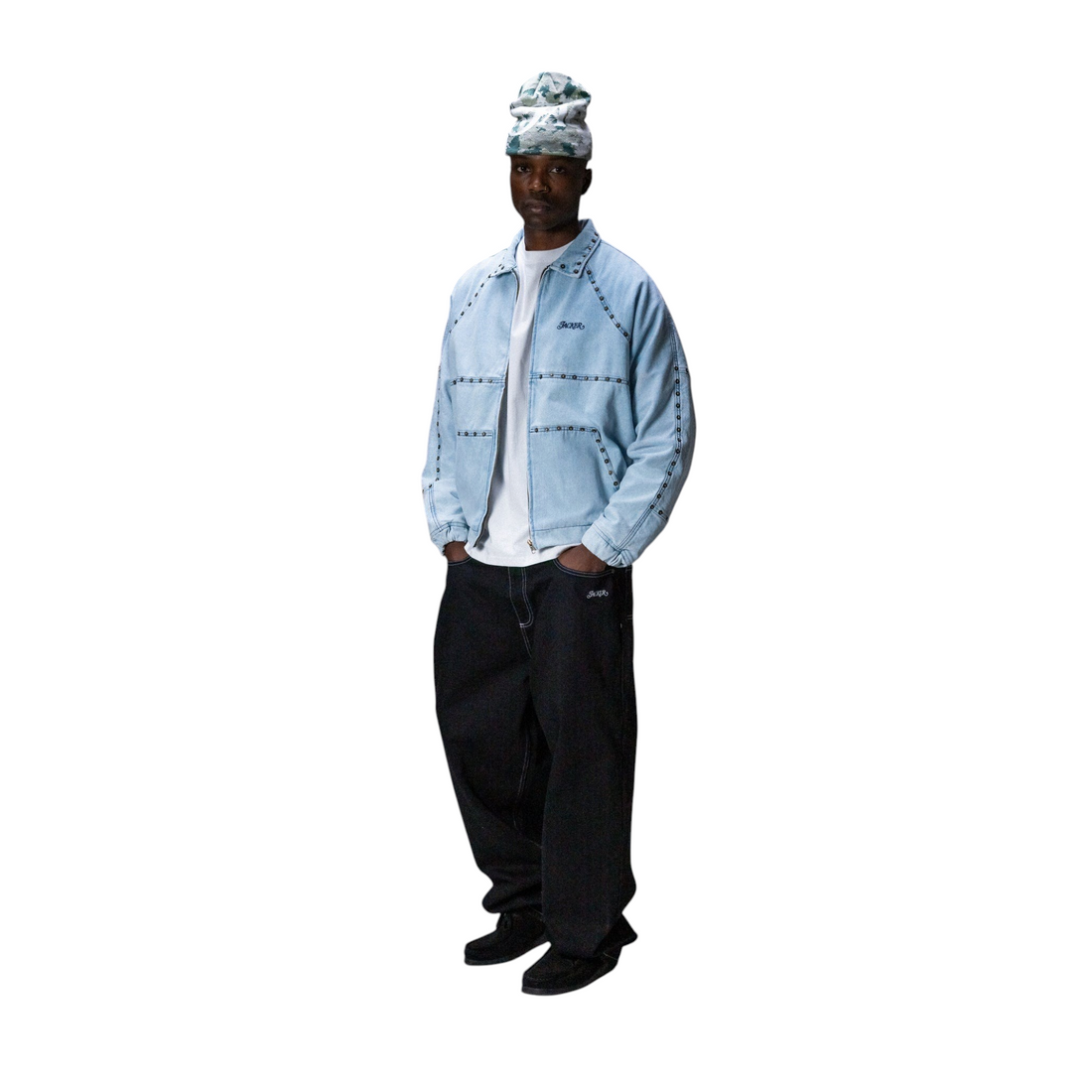 Homme portant une veste en jean bleu clair Jacker Rivet avec finitions rivetées et un bonnet sur fond gris
