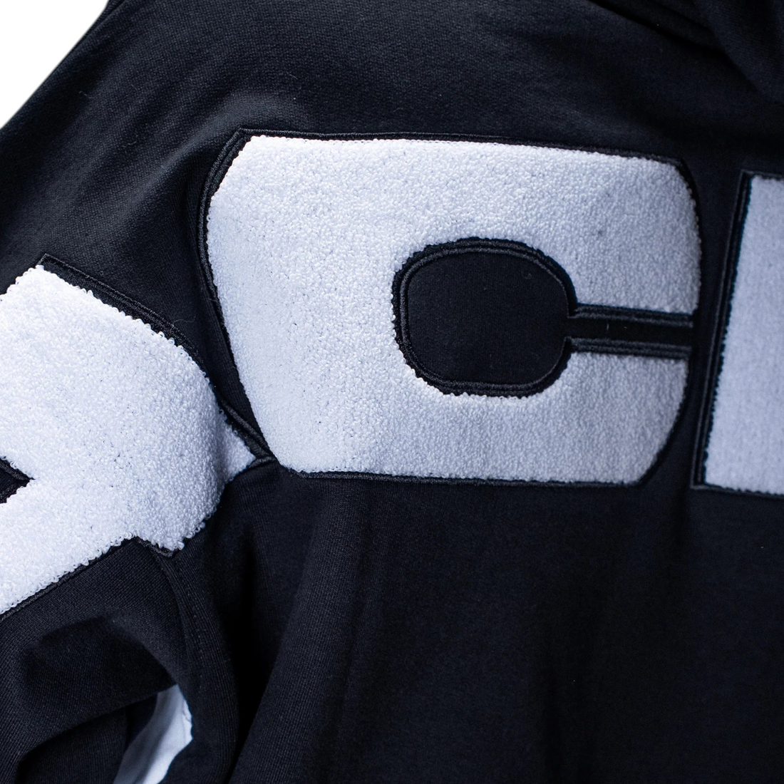 Gros plan sur le sweat à capuche Born2ride Jacker Yetorius noir en coton épais avec logo brodé en relief blanc