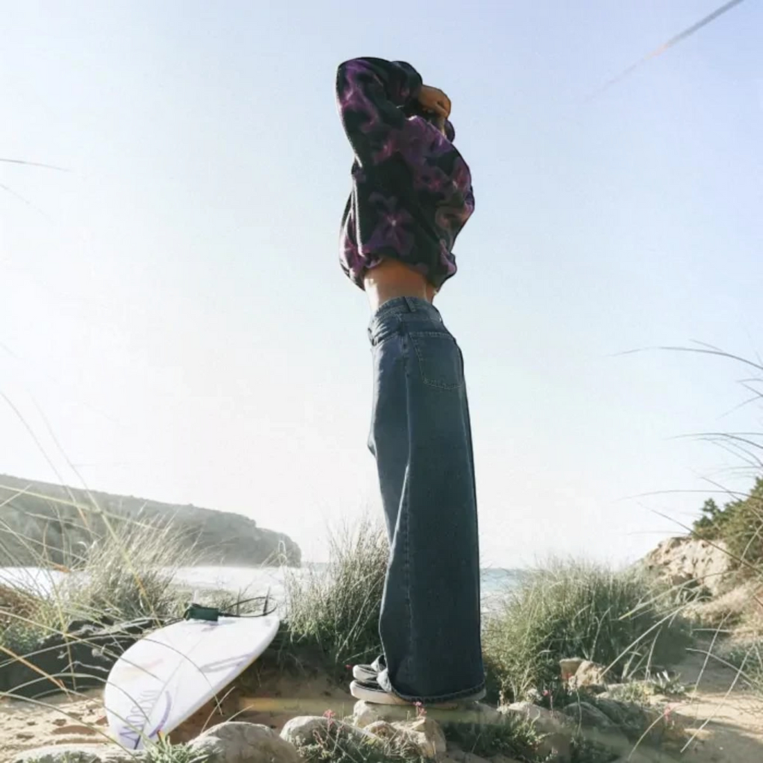 Femme portant un jean loose Born2ride Oxbow Denim-pt couleur ink en coton sur une plage avec une planche de surf