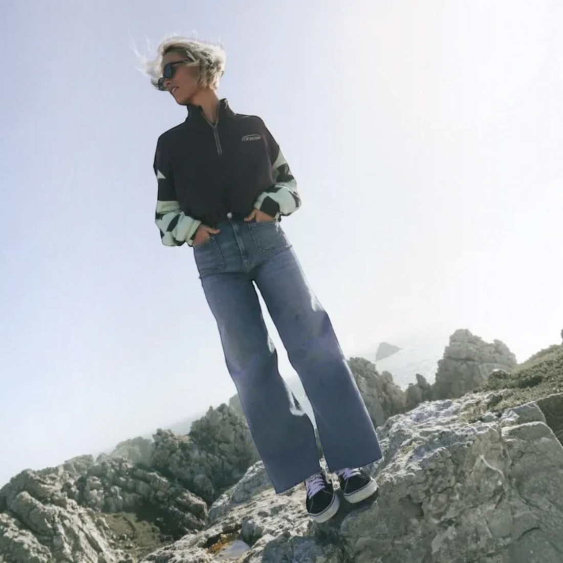 Femme portant le jean Born2ride Oxbow Mariner-pt bleu vintage coupe droite sur un rocher en bord de mer