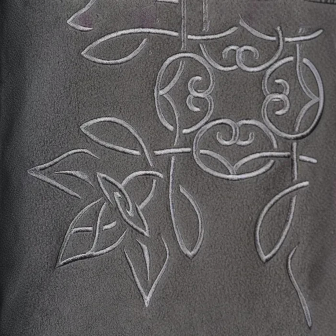Gros plan sur le motif brodé noir de la polaire réversible Oxbow Rituals-wrm chez Born2ride