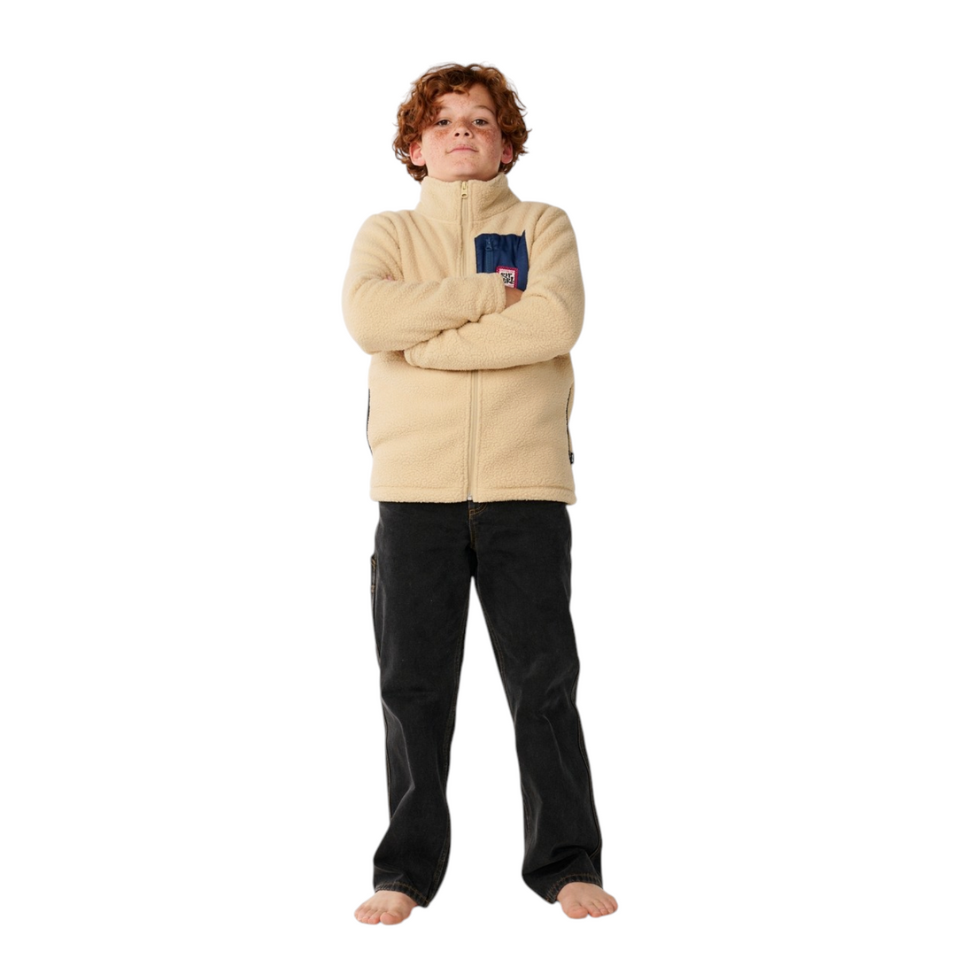 Garçon portant une veste polaire Born2ride Rip Curl beige avec poche poitrine bleue sur fond blanc