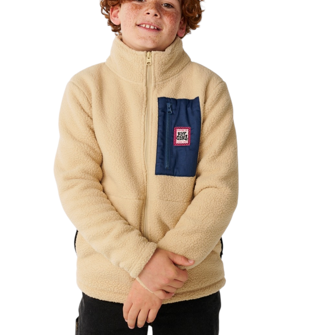 Garçon portant une veste polaire Born2ride Rip Curl beige avec poche poitrine bleue zippée