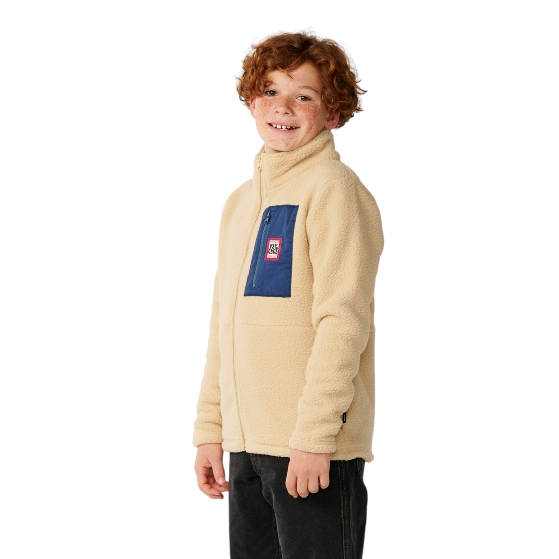 Garçon portant une veste polaire Born2ride Rip Curl beige avec poche poitrine bleue zippée et col montant