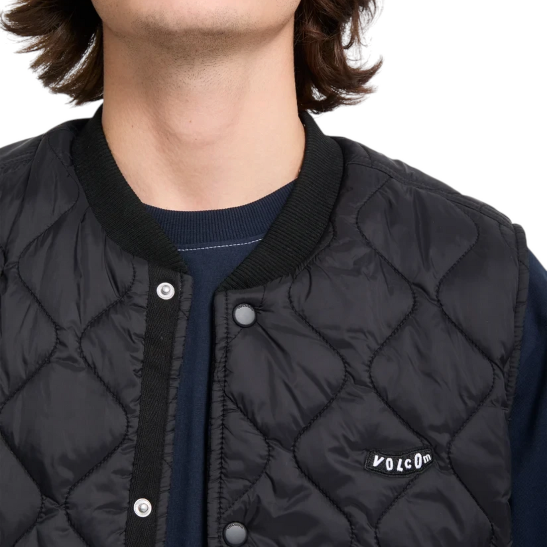 Gilet matelassé noir Born2ride Volcom Bowered avec fermeture à boutons-pression et col côtelé porté par un homme