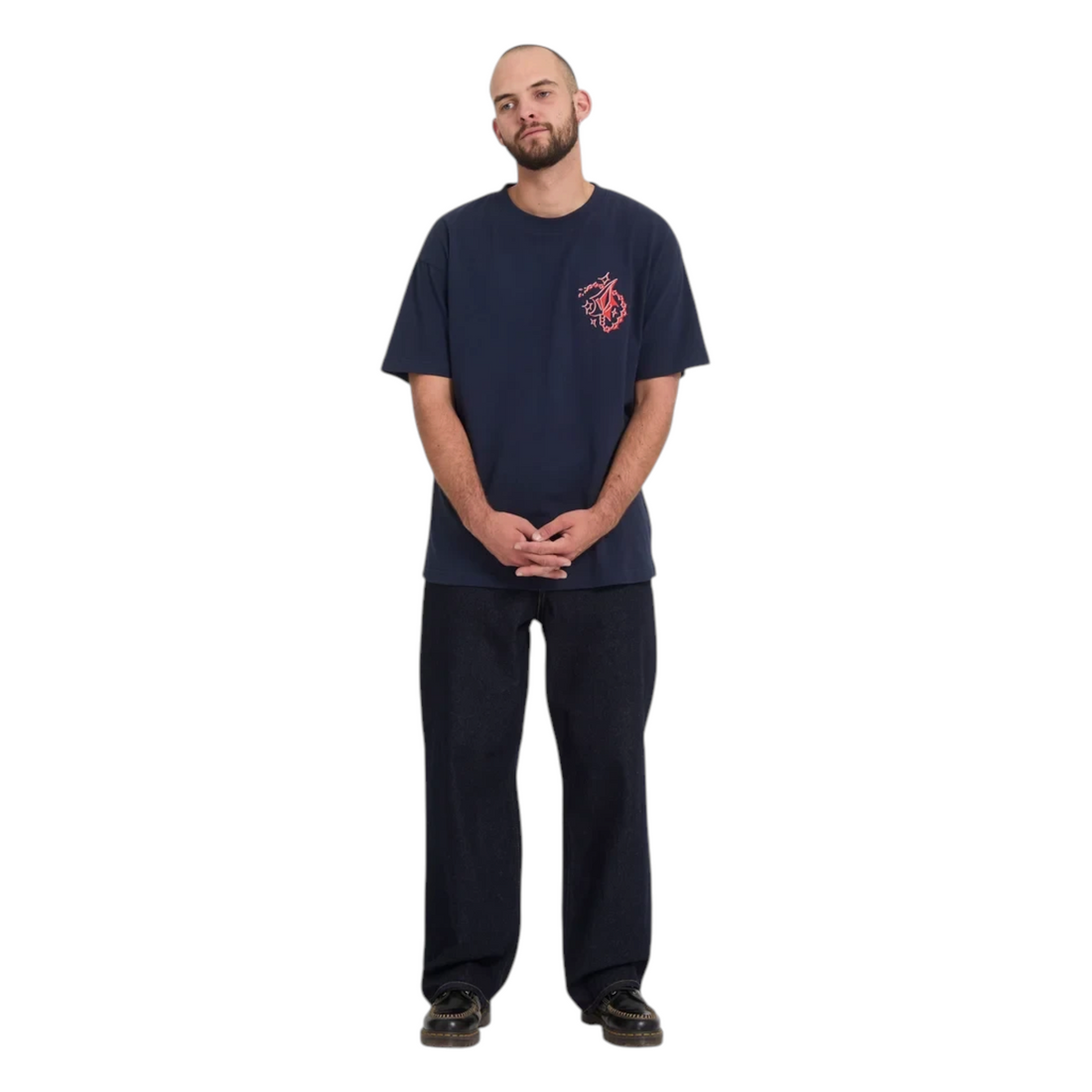 Homme portant un jean Born2ride Volcom Billow Denim brut coupe loose et un t-shirt bleu marine à motif