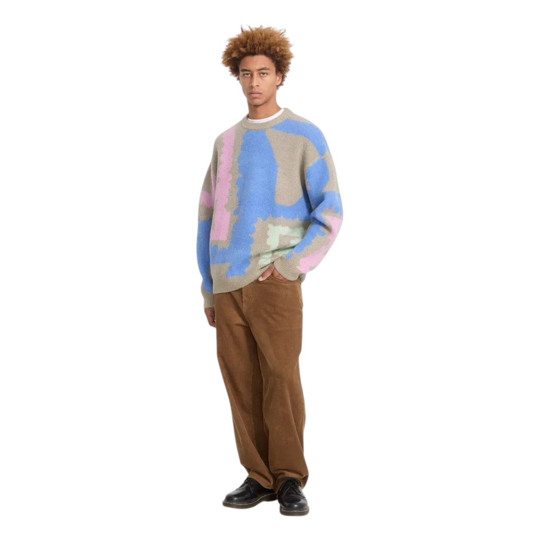 Homme portant le pull Born2ride Volcom Fa Carrau à motifs abstraits bleus, roses et verts sur fond beige