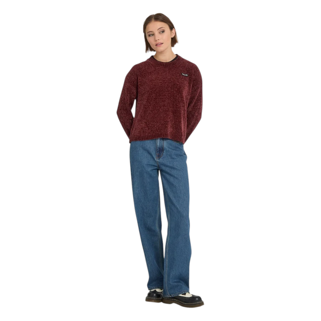 Femme portant le pull en maille Born2ride Volcom Bubble Tease couleur brique avec un jean bleu et des chaussures
