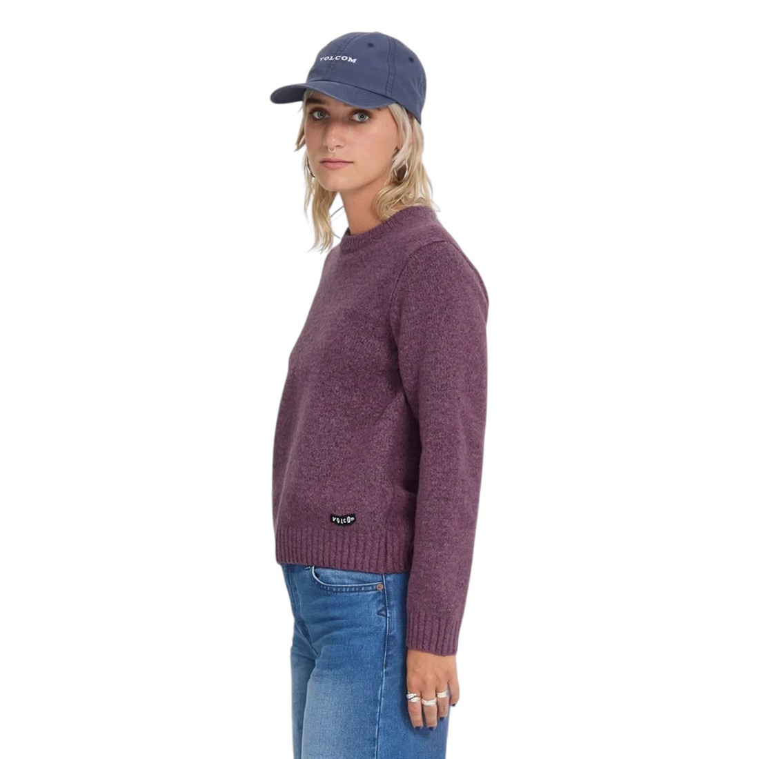 Femme portant un pull Born2ride Volcom Wedmonder en tricot orchid à col rond avec une casquette bleue