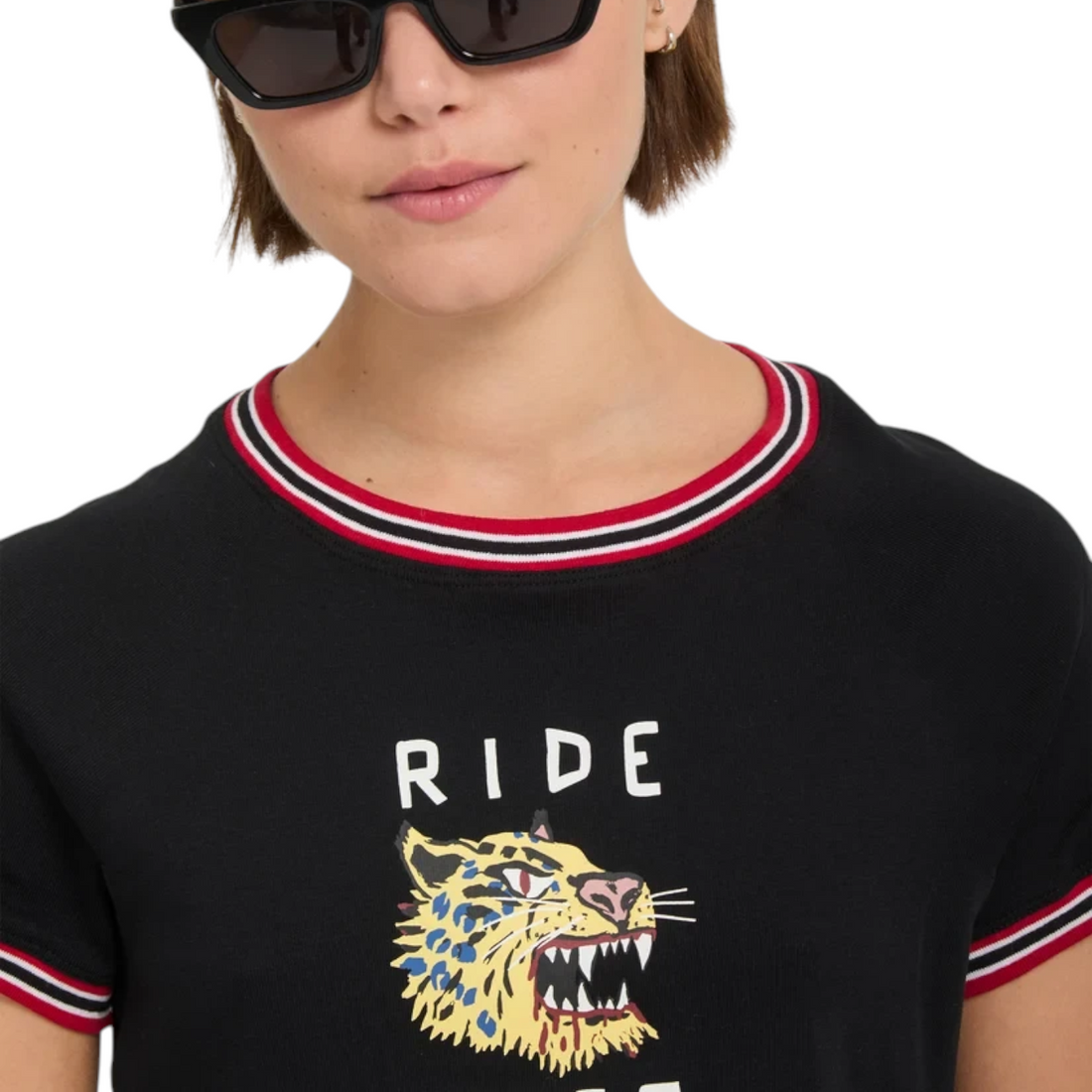 T-shirt noir Born2ride Volcom FA Ozzy avec imprimé tigre et col rayé rouge et blanc porté par une femme à lunettes